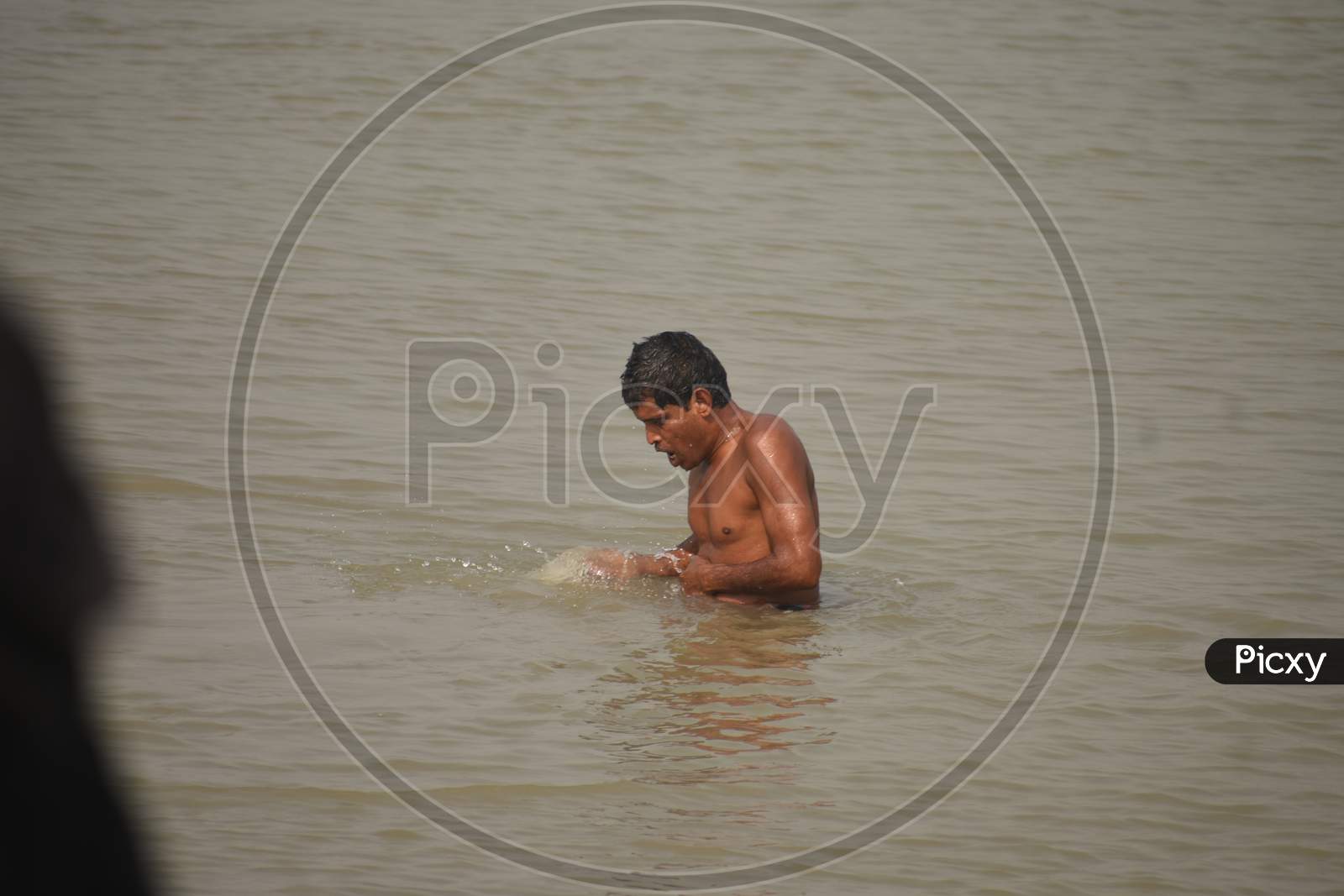 A man is  bathing in the river.