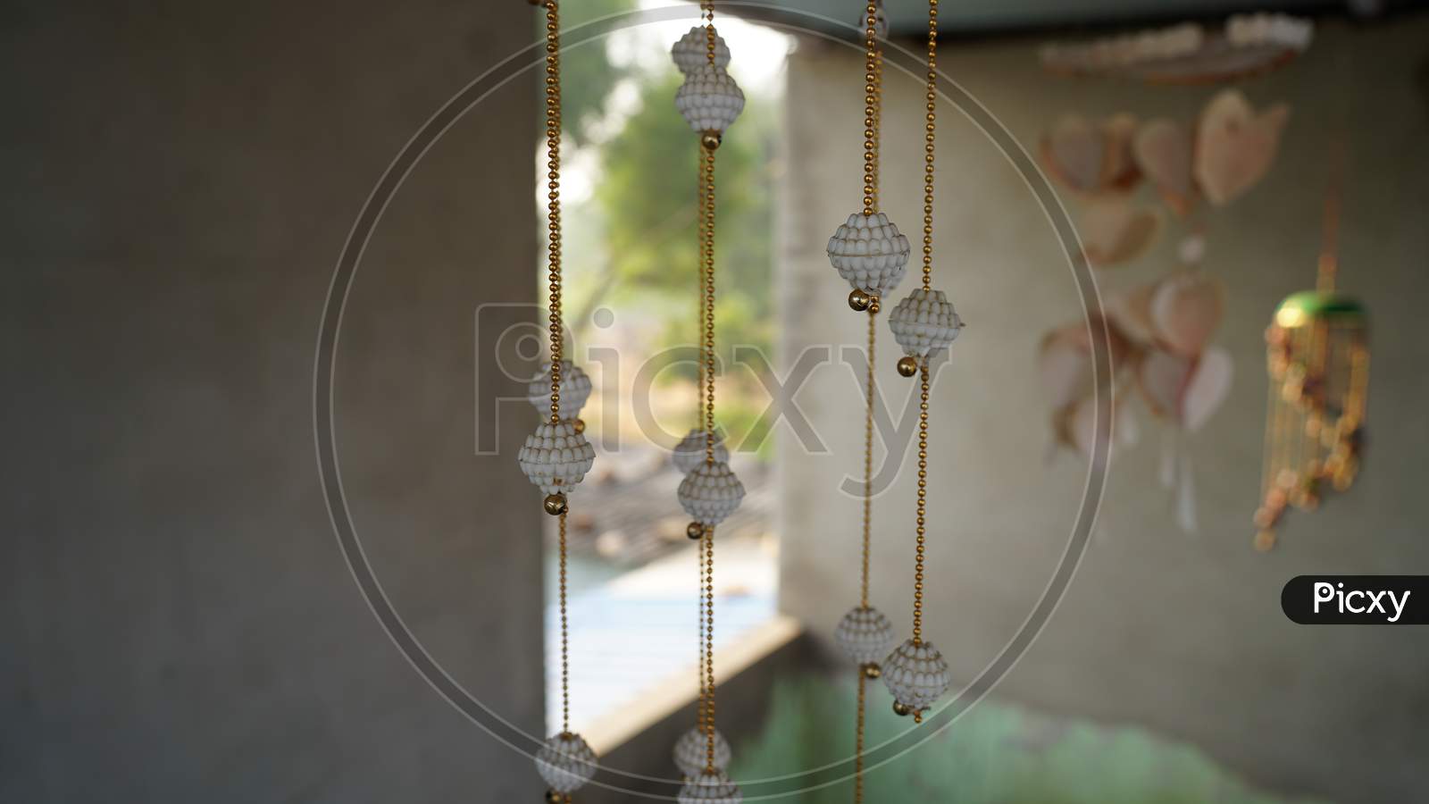 White Ceramic Bells On The Background Of The Door. Bells Close-Up. Door Hanging Or Decorations Closeup.