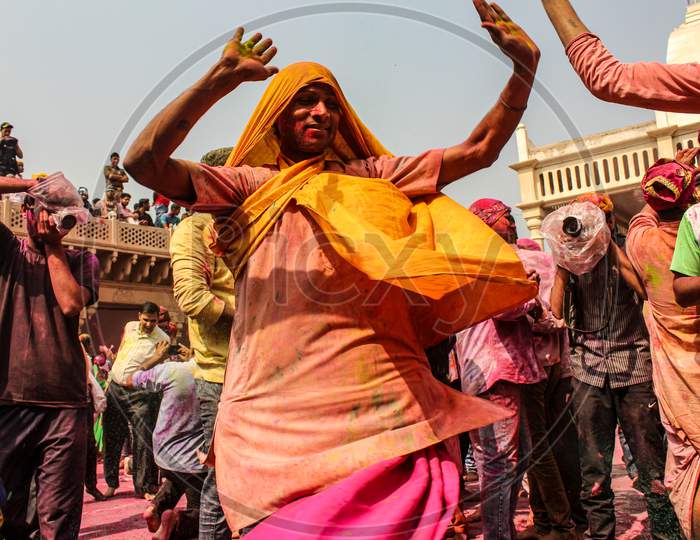 Mathura, Uttar Pradesh, India- January 28 2020: Young Indian Man Dancing With A Yellow Colored Cloth Covered In Holi Colors, Enjoying During The Holi Festival In Mathrua.