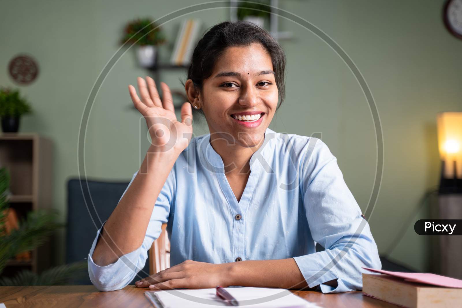 Image of Young Business Woman Saying Hai Gesture Or Waving Hands To Camera  - Concept Of Video Chat, Conference Or Vlogging From Home By Looking At  Camera.-WA018795-Picxy