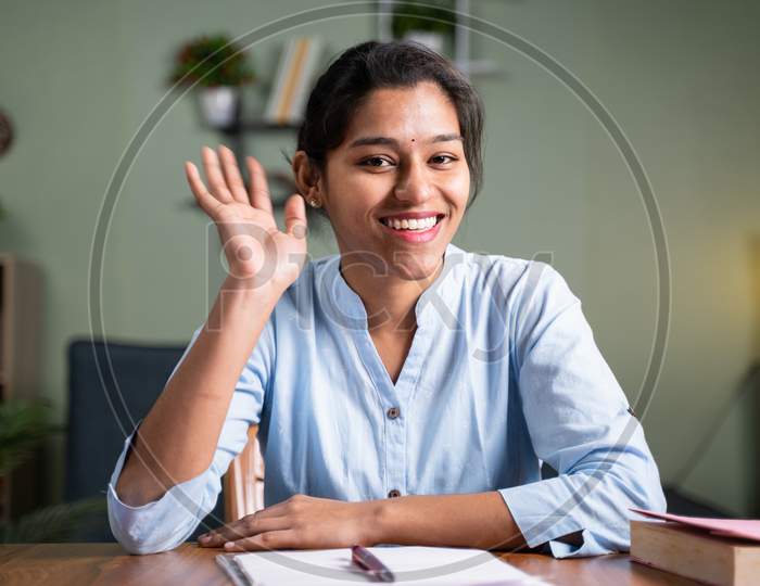 Young Business Woman Saying Hai Gesture Or Waving Hands To Camera - Concept Of Video Chat, Conference Or Vlogging From Home By Looking At Camera.