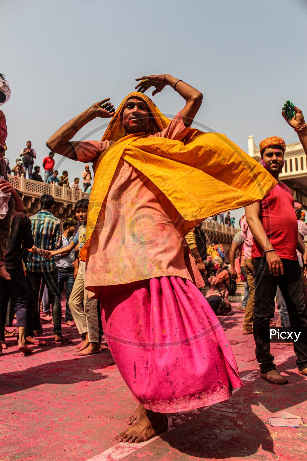 Mathura, Uttar Pradesh, India- January 28 2020: Young Indian Man Dancing With A Yellow Colored Cloth Covered In Holi Colors, Enjoying During The Holi Festival In Mathrua.