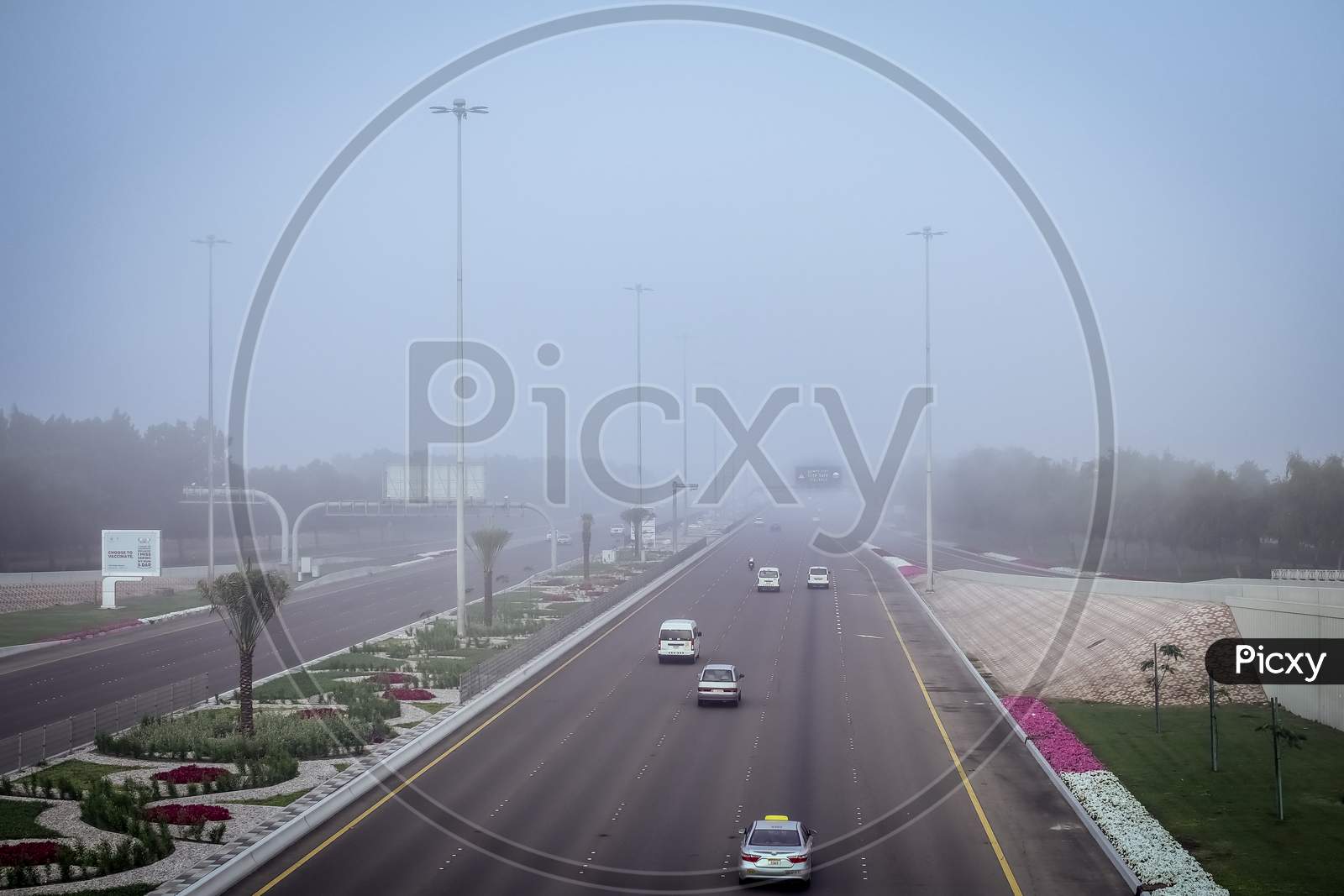 Road In The Fog, Sign Mention Keep Distance For Motorists At Dubai Road, Foggy Weather In Uae, Dense Fog Keep Safe Distance Banner In Arabic And English
