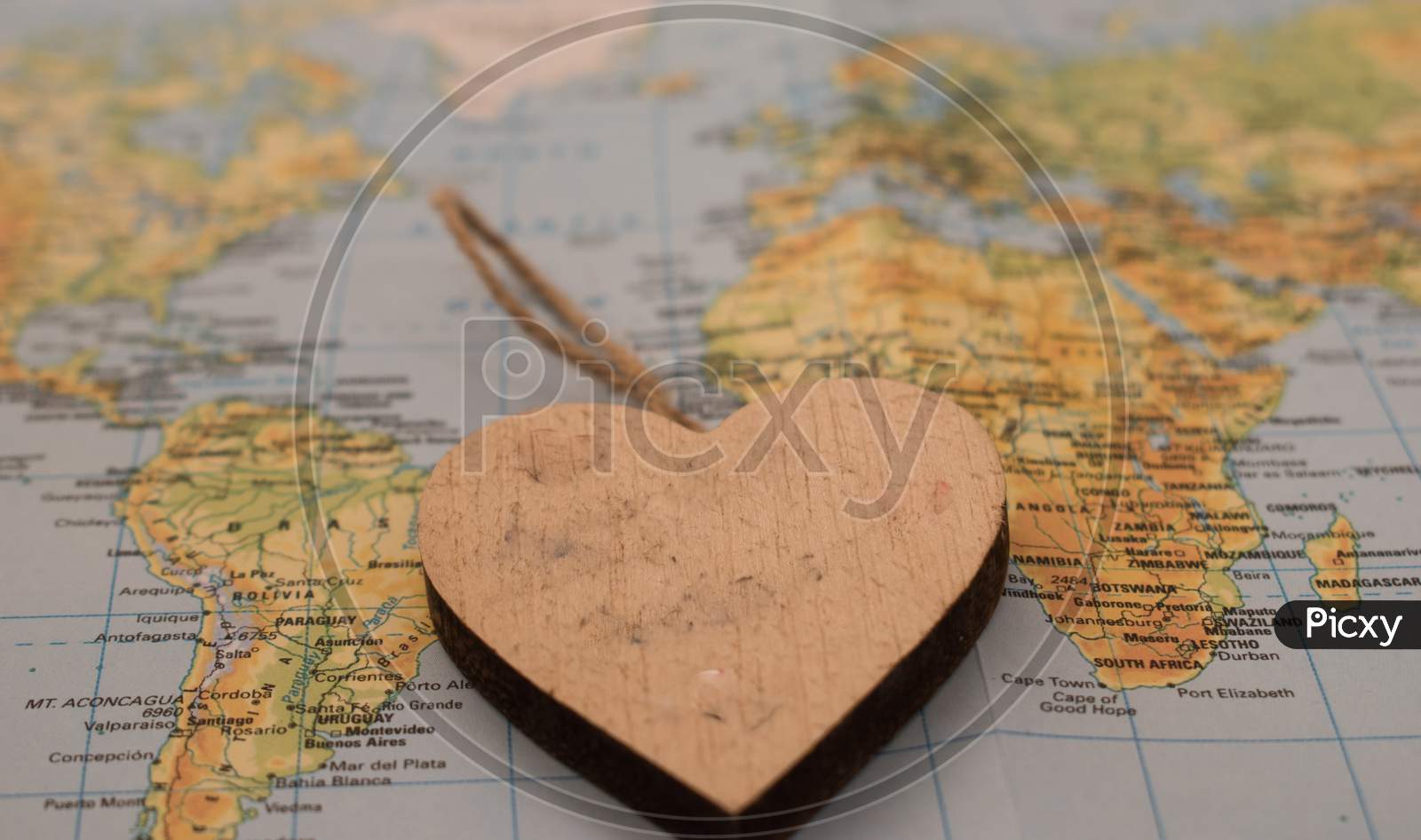 A Wooden Heart Over A Global Map