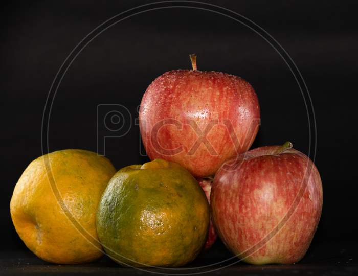 Apples And Oranges Arranged In Black Background