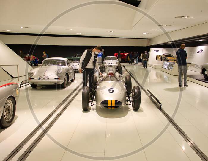 Man Looking At A Vintage Racing Car On Display In The Porsche Museum In Stuttgart, Germany.