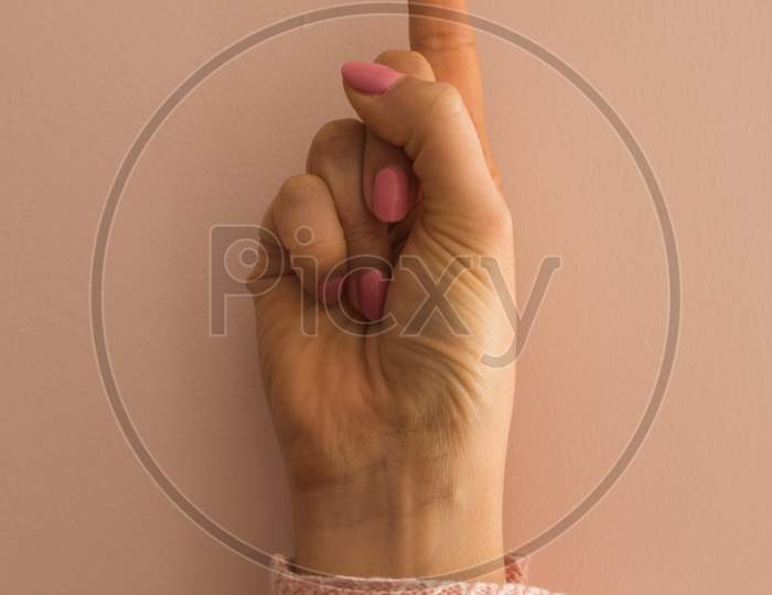 A Female Hand With The Index Finger Pointing Up