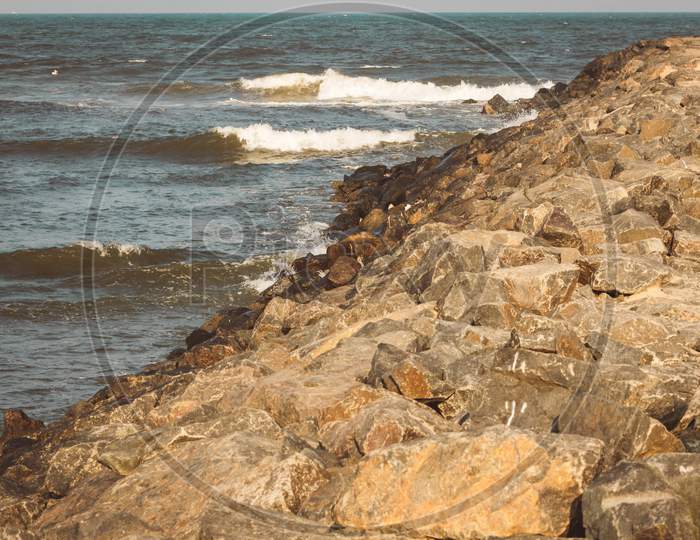 Scenic View Of Rocks With The Bay Of Bengal In The Background Along Kovalam Beach, Chennai, India
