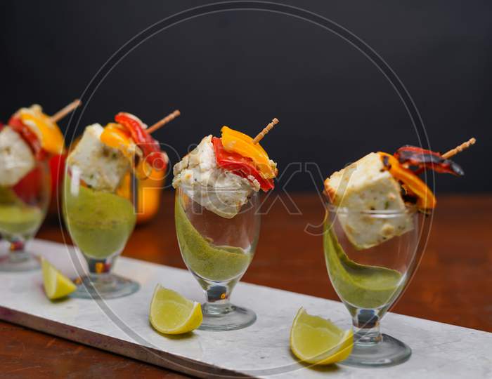 Indian Paneer Tikka Served In Glass With Green Chatni.