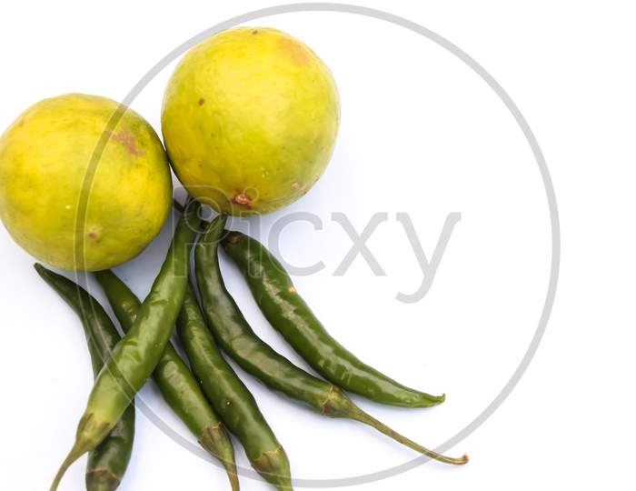 Green chillies and lemon on white background