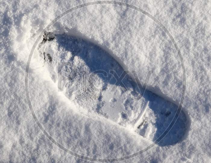 Footsteps Of Male Shoes In Fresh White Snow In Winter