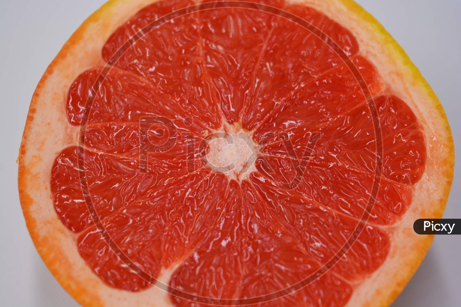 Ripe and tasty fruits, fresh grapefruit cut in half, sliced grapefruit set on a green fabric background.