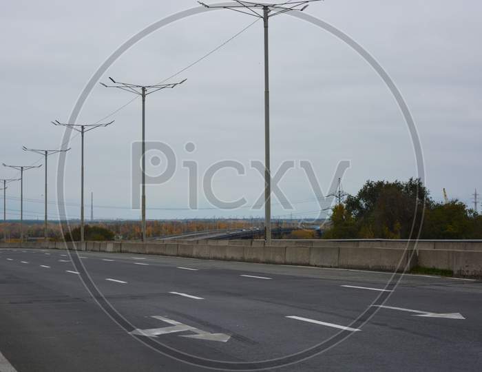 Gray long wide roads, highways of the city of Kamianske. An industrial landscape with an intense life and work.