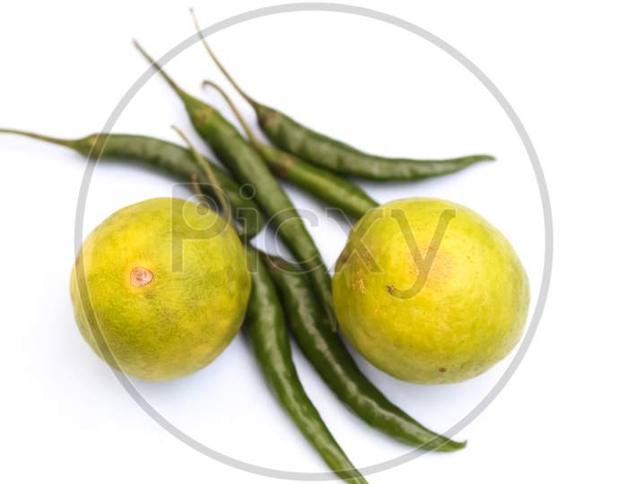 Green chillies and lemon on white background