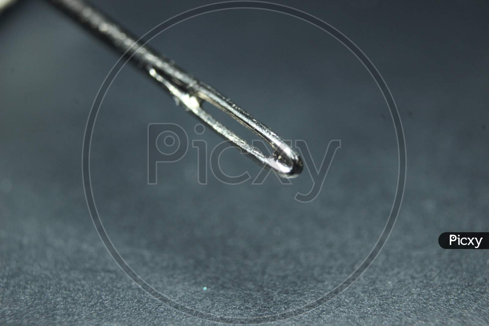 Small Needle With Empty Eyelet, Isolated Over The Black Background.