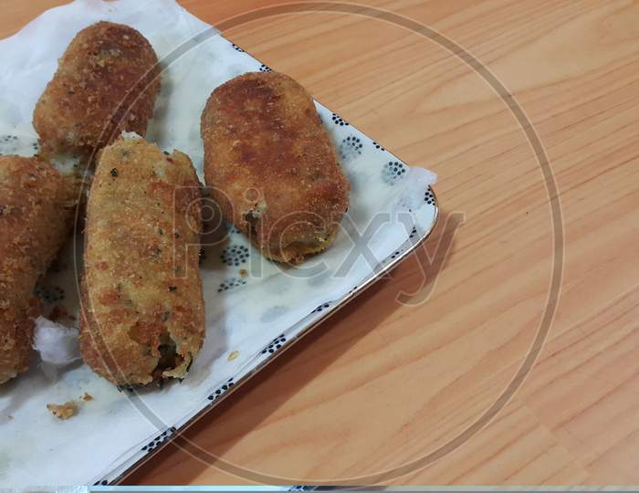 Spicy And Delicious Croquettes Served In Ceramic Plate Over Wooden Floor