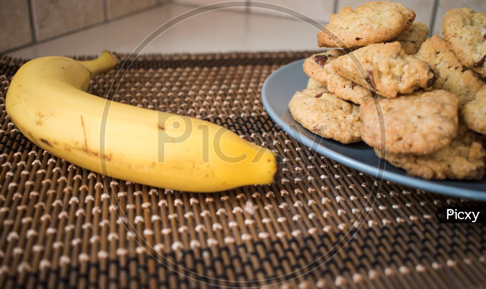 A Plate With Chocolate Chips Cookies And One Banana