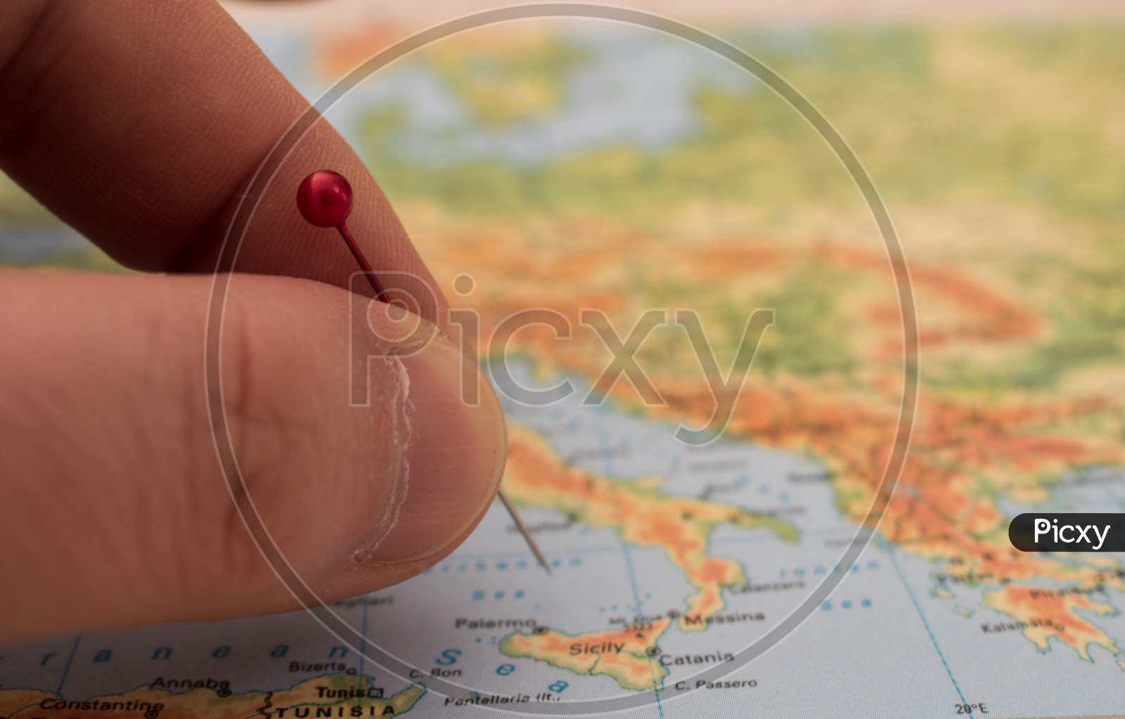 Close Up On A Hand Placing A Pin On A Map