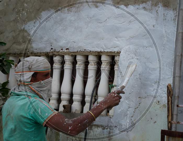 Professional Indian Painter Working With Brush Of Exterior Wall. House And Building Renovation Concept.