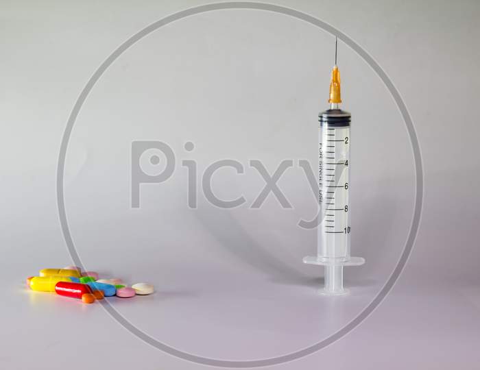 Colored Pills On A White Background With Free Space To Write. Subcutaneous Needle Syringe. Concept Of Legal Drug Use