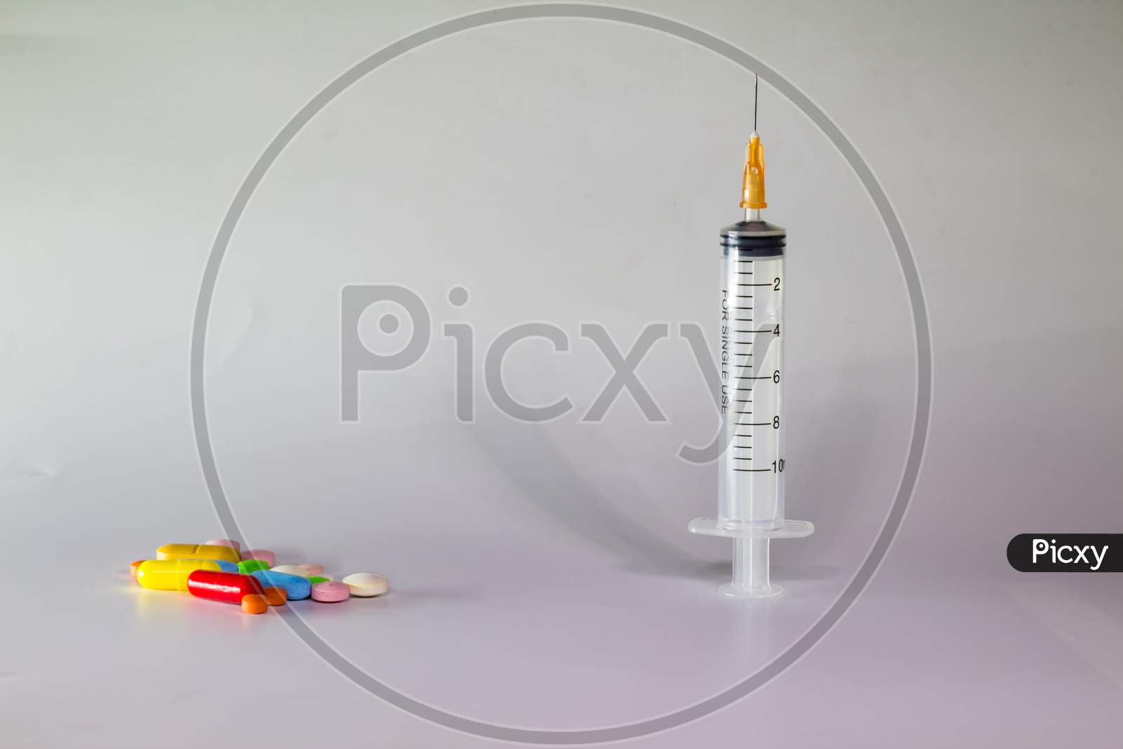 Colored Pills On A White Background With Free Space To Write. Subcutaneous Needle Syringe. Concept Of Legal Drug Use