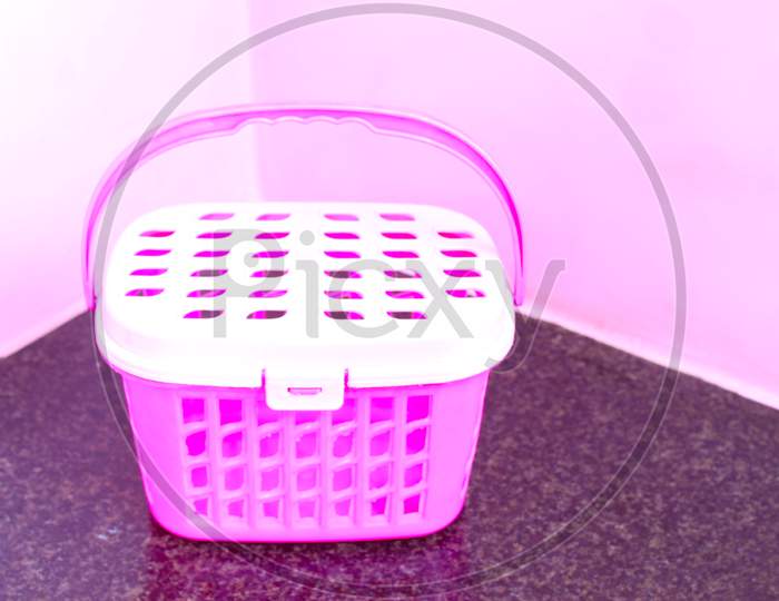 Pink Plastic Basket Isolated On Texture Background