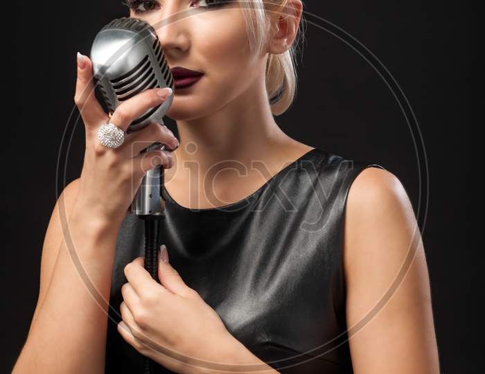 Woman Holds A Metal Microphone