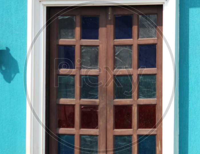 Close Up View On A Arched Colorful Window With Wooden Frame