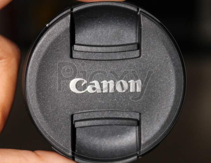 Canon camera lens cap holding in hand