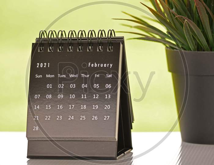 Black February 2021 Calendar With Green Backgrounds And Potted Plant