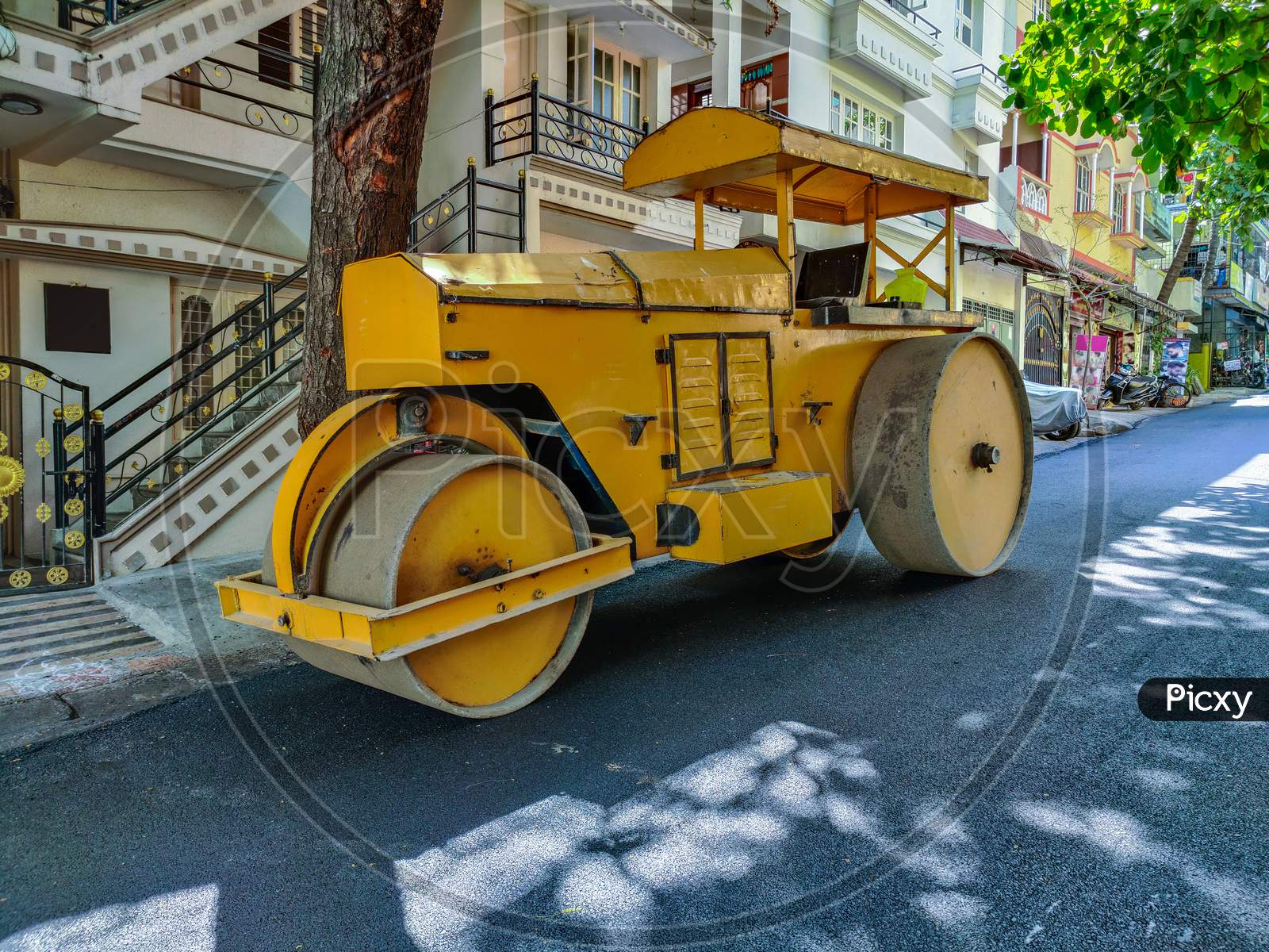 Stock Photo Of A Yellow Color Road Roller Parked On The Newly Constructed Damber Road For Rolling Black Topping For Renovation Of Road At Bangalore City Karnataka India.