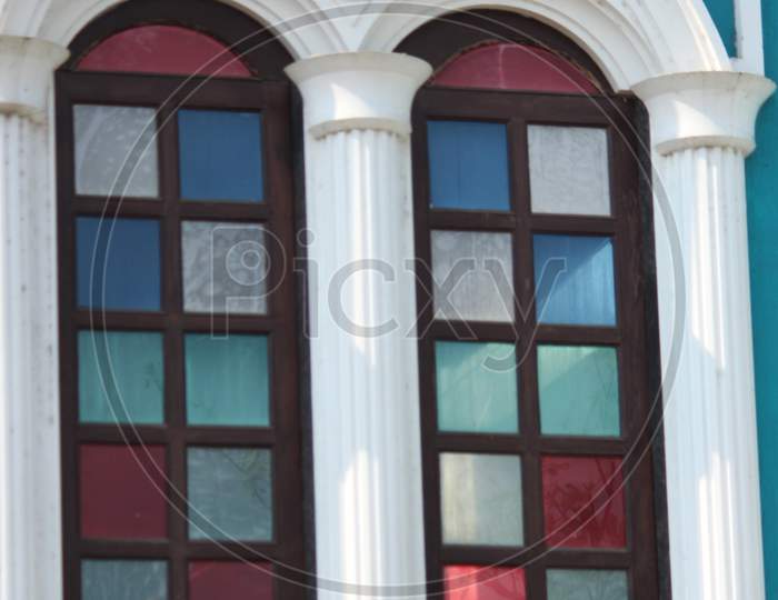 Close Up View On A Arched Colorful Window With Wooden Frame