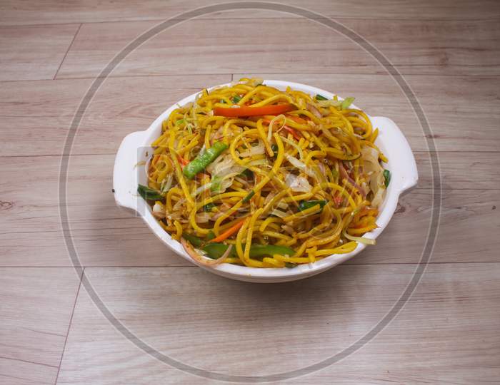 Egg Noodles With Barbeque Pork On Chinese Plates On A Wooden Table And Garnish