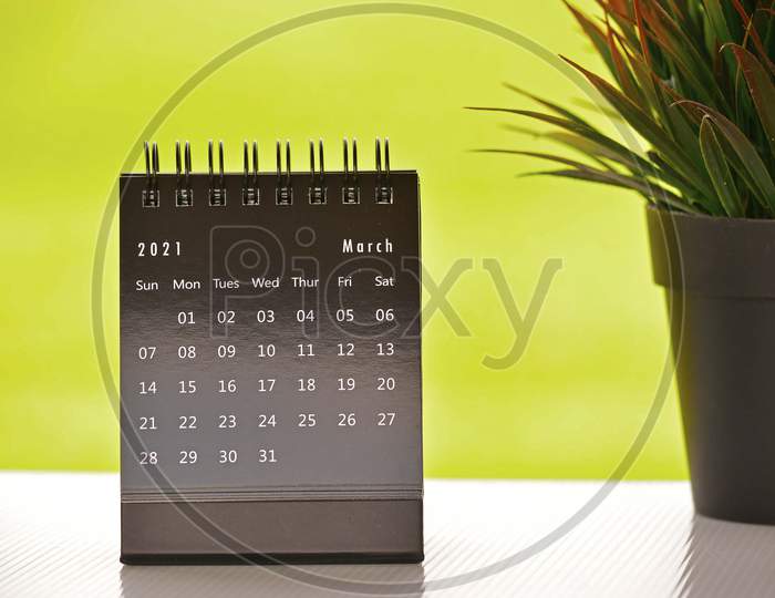 Black March 2021 Calendar With Green Backgrounds And Potted Plant. 2021 Concept