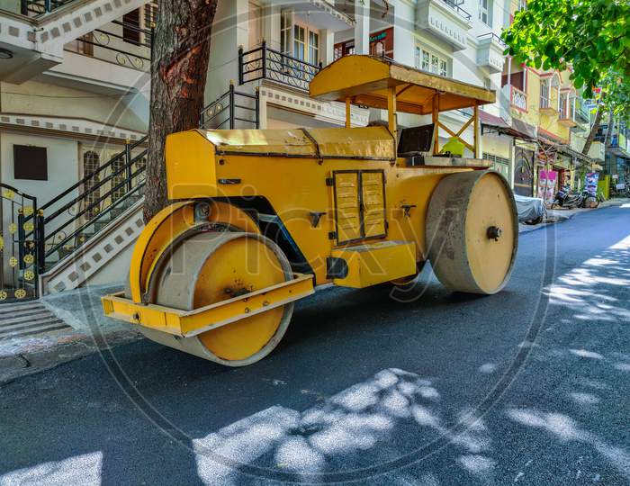 Stock Photo Of A Yellow Color Road Roller Parked On The Newly Constructed Damber Road For Rolling Black Topping For Renovation Of Road At Bangalore City Karnataka India.