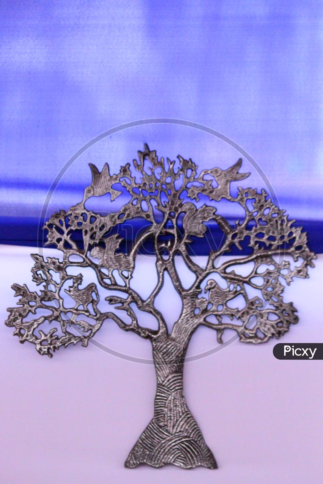 Bonsai Metal Tree Isolated With Blue And Pink Background.