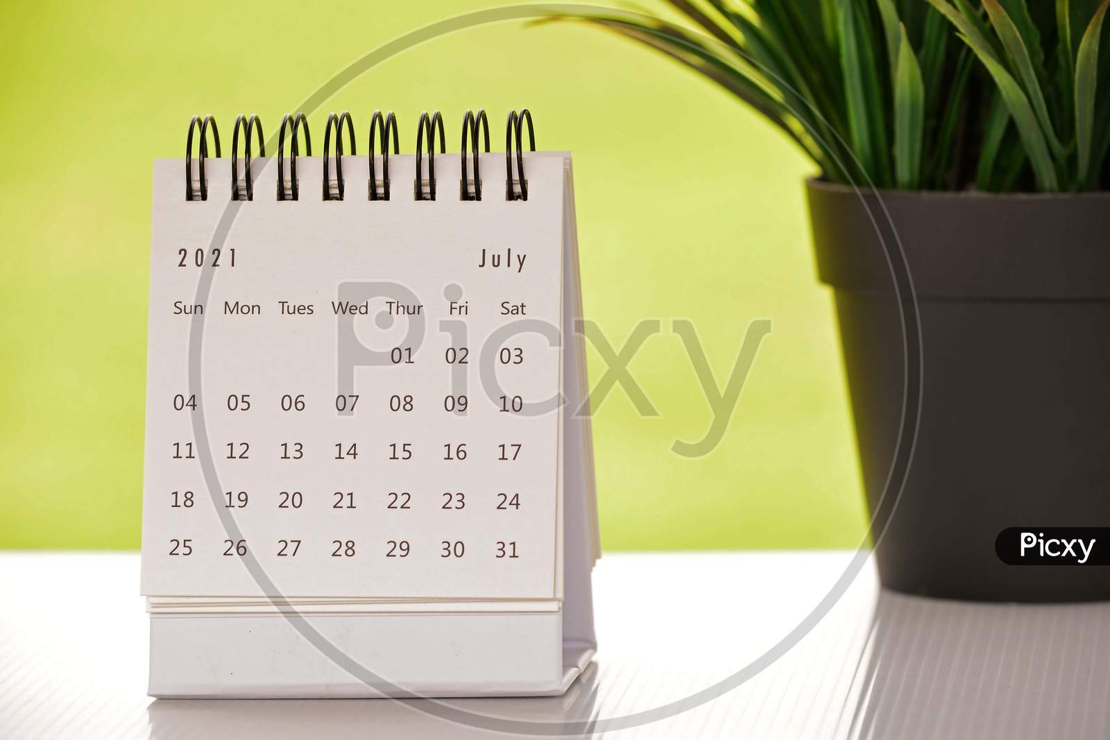 White July 2021 Calendar With Green Backgrounds And Potted Plant. 2021 New Year Concept