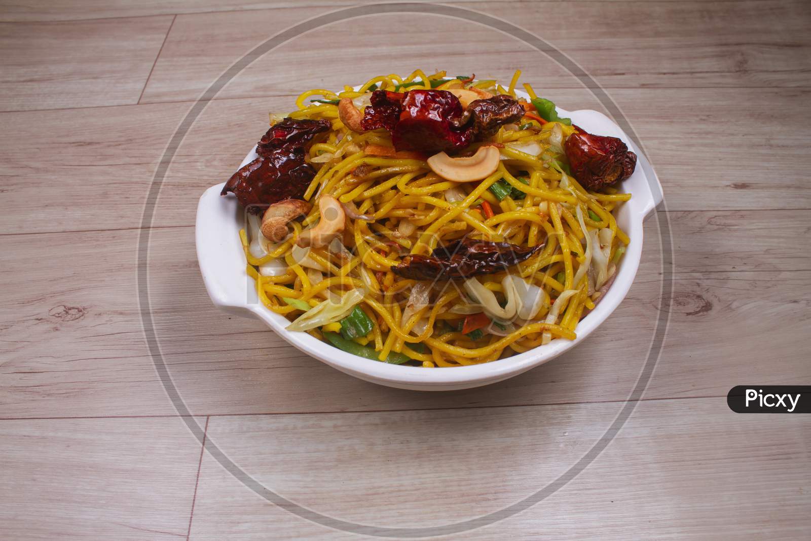 Egg Noodles With Barbeque Pork On Chinese Plates On A Wooden Table And Garnish