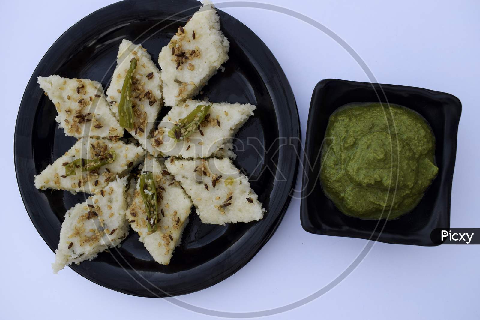 Vrat Ka Khana Farali Gujarati Cuisine. Faral Ka White Dhokla Made From Sago Flour And Garnished With Green Chilly And Sesame Seeds. Eaten During Vrat Upawas Fasting Food From Gujarat India.