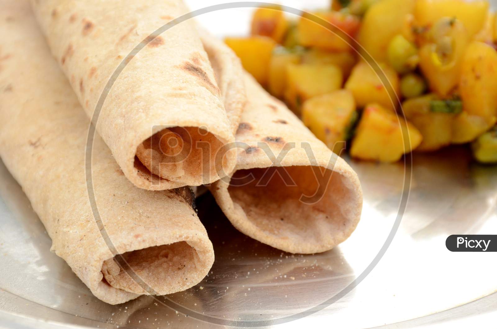 The Brown Unleavened Bread With Potato Peas Vegetable Made On The White Background.