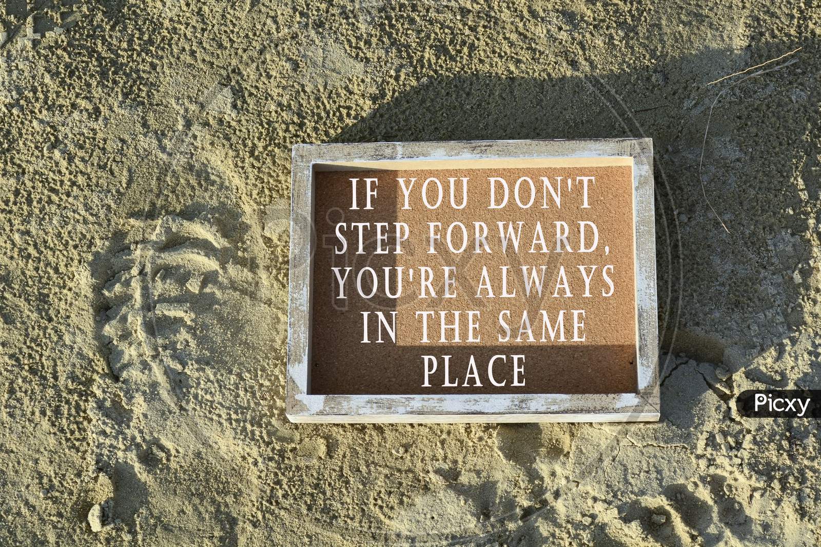 Text On Wooden Frame Laying On Sandy Beach