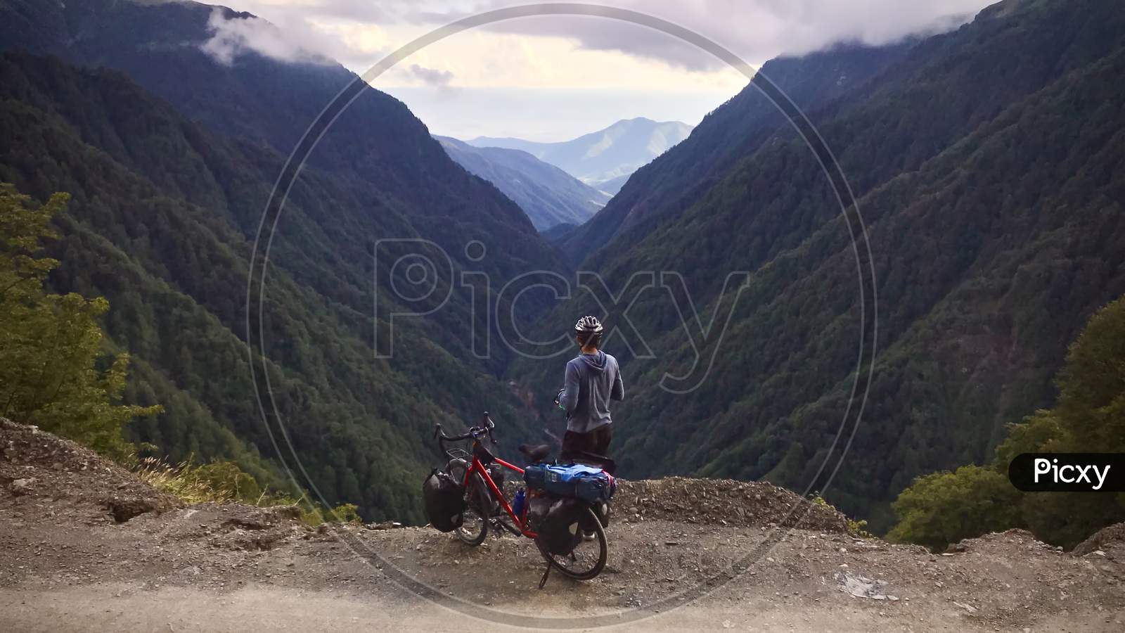 Back View Cyclist Standing With Touring Bicycle Edge Admire Majestic Caucasus Mountains. Tusheti Travel Destination
