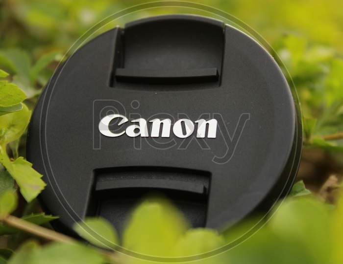Black Plastic Canon Camera Lens Cap on the grass