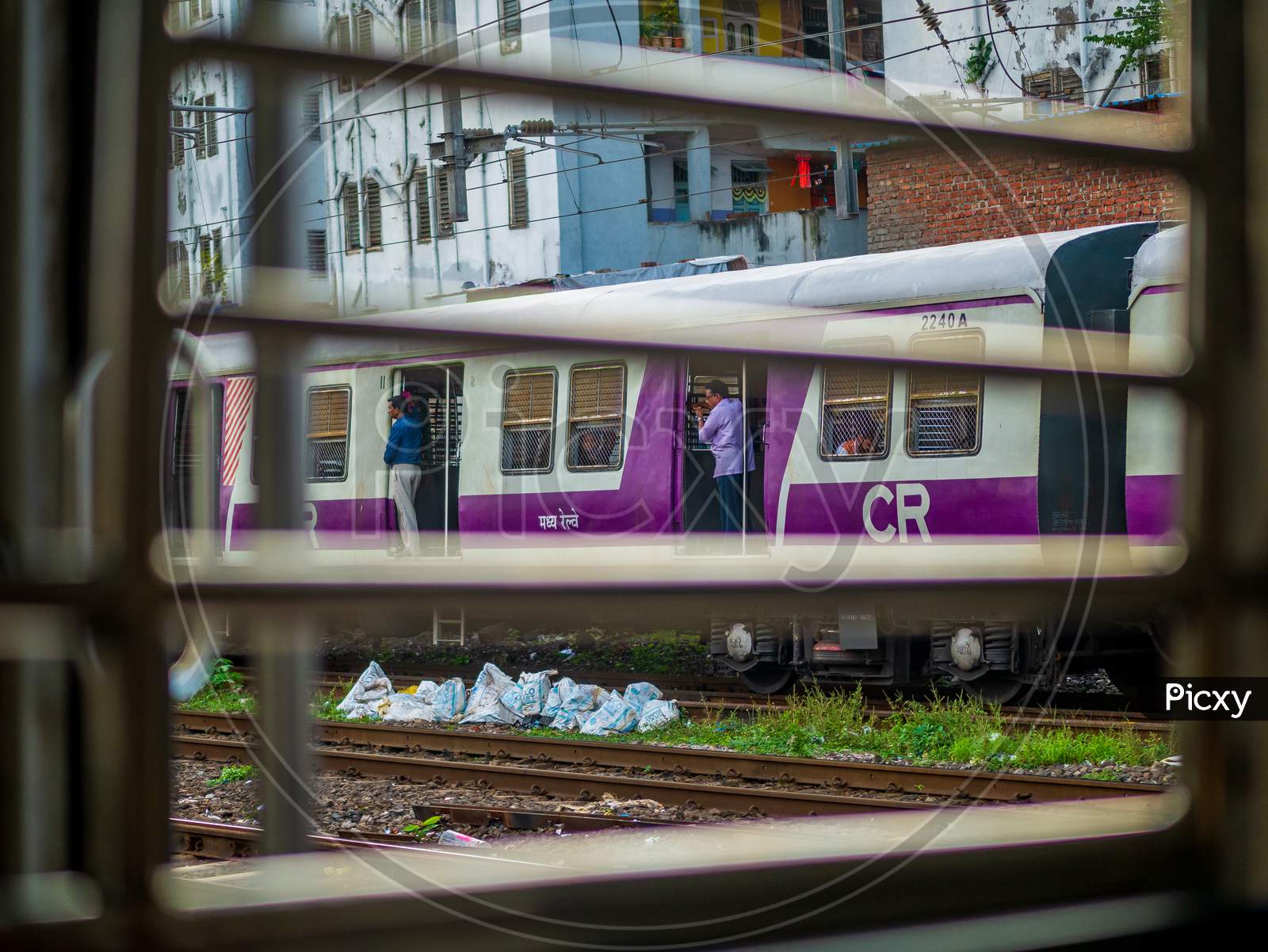 Unidentified Passengers Standing On The Doors Of Running Local Train During Rush Hours