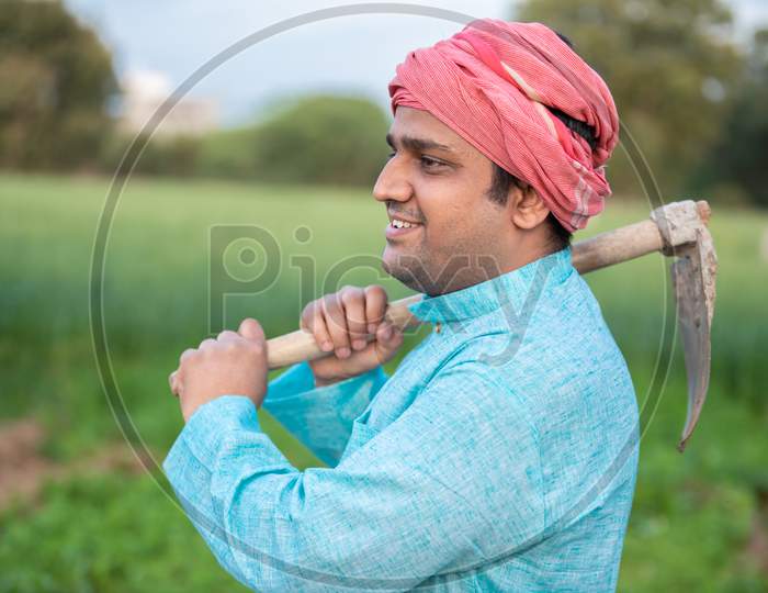 Portrait Of Happy Indian Male Farmer Labor Worker Holding Pretail Garden Spade / Shovel Or Agricultural Tool.