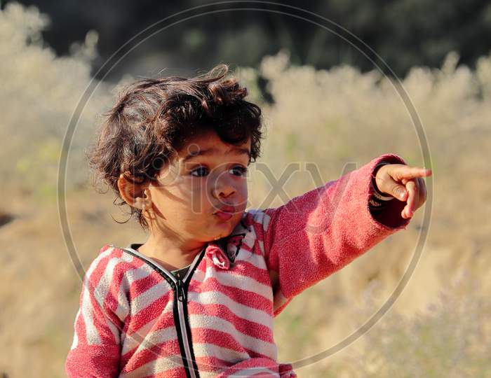 A Little Boy Of Indian Origin Is Seen Looking Away From His Finger And Hand.