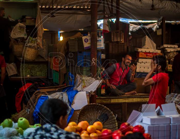 A Fruit Vendor On Mobile Video Call In A Fruit Market In South Mumbai