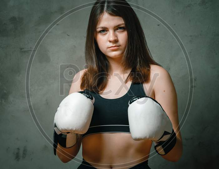 Young Fighter Girl With White Gloves Fighting Practice Throwing Aggressive Boxing Workout On Black Dirty Grunge Background