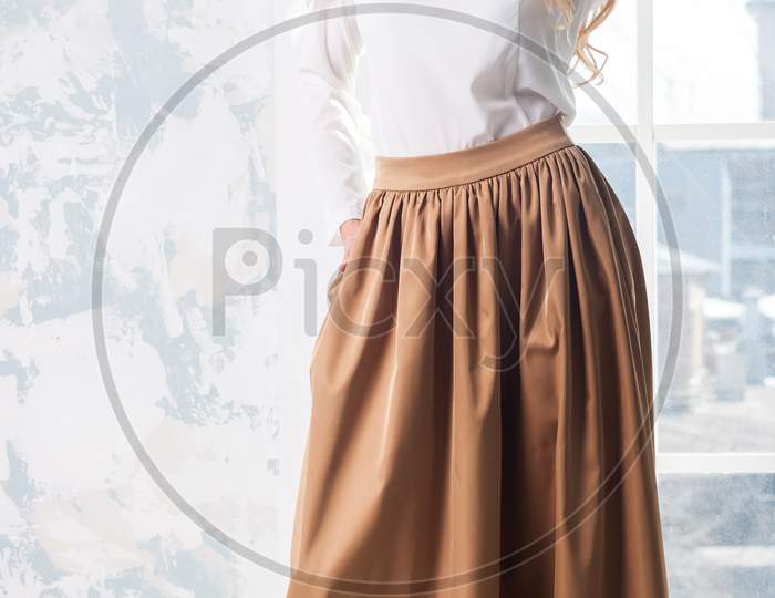 Blonde In A Fashionable Blouse And Beige Fashionable Skirt