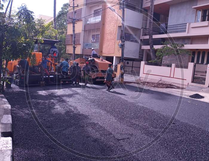 Workers with Asphalting machine during Road street repair work.